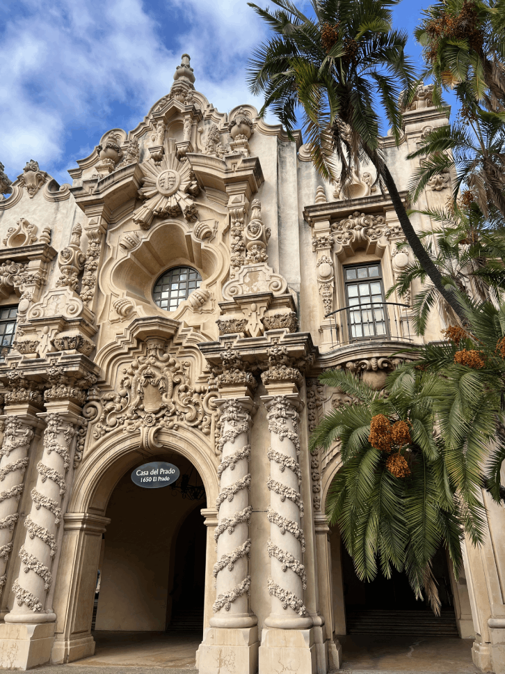 Ornate Spanish Colonial Revival architecture of Casa del Prado with decorative columns and palm trees.