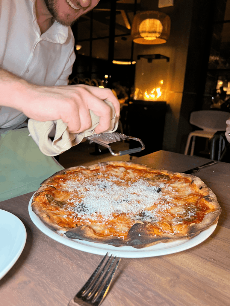 The pizza with freshly shaved cheeese
