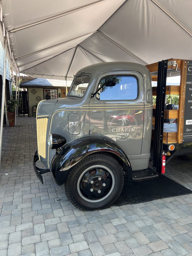 Vintage truck with "Chapin Winery" logo parked under a tent.