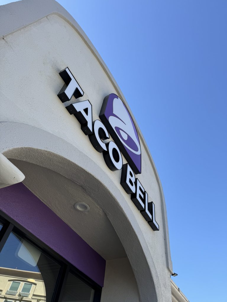 Taco Bell restaurant entrance with a blue sky background.